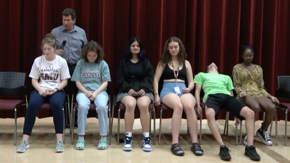 Comedy hypnotist Boris Cherniak performing a school show